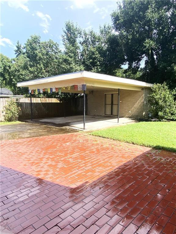 view of patio / terrace with decorative driveway and fence