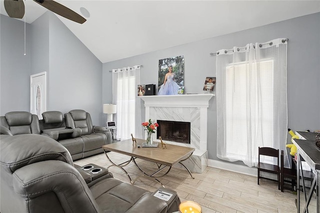 living room featuring a wealth of natural light, light hardwood / wood-style flooring, ceiling fan, and a fireplace