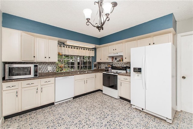 kitchen with light tile patterned flooring, white appliances, an inviting chandelier, and tasteful backsplash