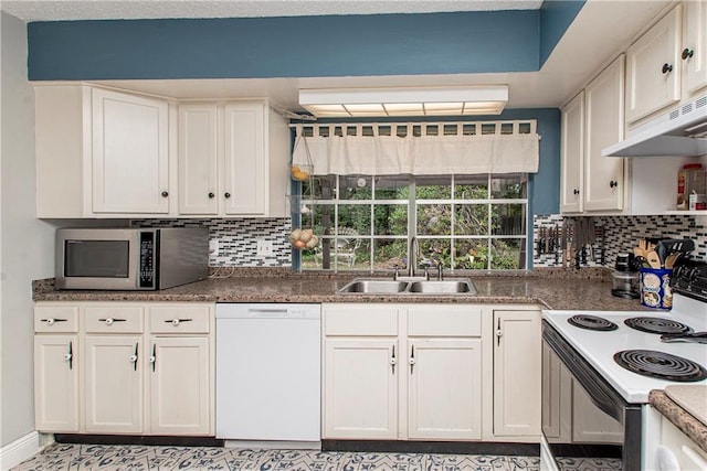 kitchen with white appliances, backsplash, white cabinetry, and sink