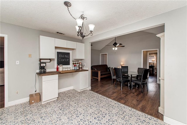 kitchen with hardwood / wood-style flooring, ceiling fan with notable chandelier, white cabinetry, butcher block countertops, and a textured ceiling