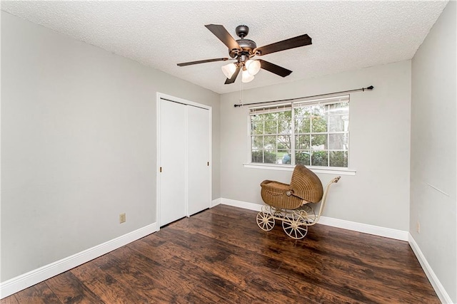 unfurnished bedroom with ceiling fan, dark hardwood / wood-style floors, and a closet