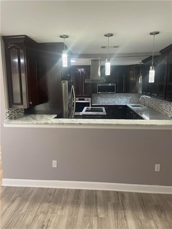 kitchen featuring appliances with stainless steel finishes, tasteful backsplash, wood-type flooring, and sink