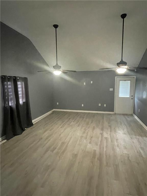 interior space with lofted ceiling, hardwood / wood-style floors, and ceiling fan