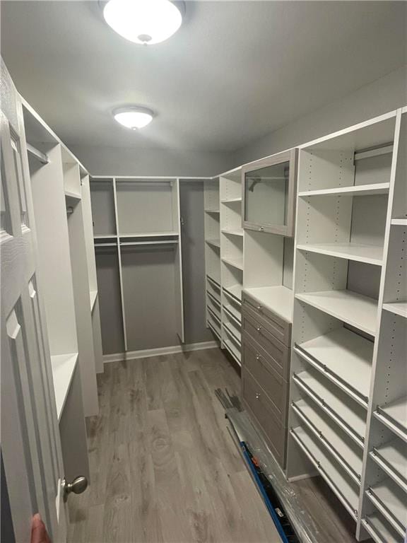 walk in closet with dark wood-type flooring