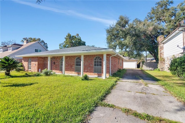 single story home featuring a garage, a front lawn, and an outdoor structure