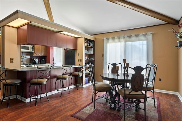 dining area featuring vaulted ceiling with beams and dark wood-type flooring