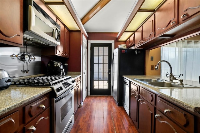 kitchen with appliances with stainless steel finishes, a healthy amount of sunlight, dark hardwood / wood-style flooring, and sink