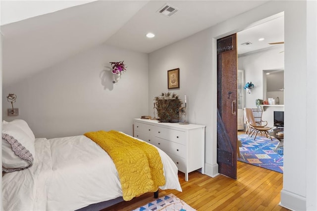 bedroom featuring light hardwood / wood-style flooring and lofted ceiling