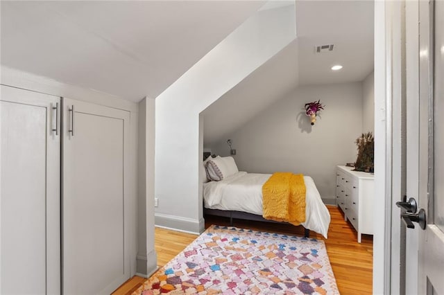 bedroom with light hardwood / wood-style flooring and lofted ceiling