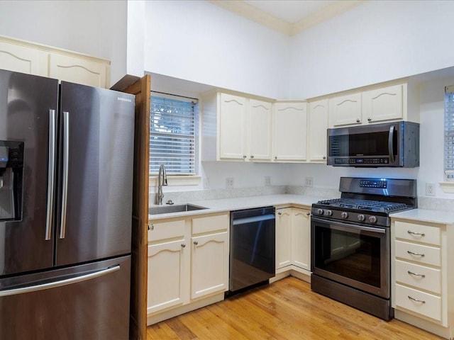 kitchen featuring light wood-type flooring, stainless steel appliances, and sink