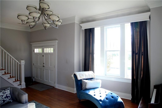 entrance foyer featuring an inviting chandelier, a healthy amount of sunlight, crown molding, and dark hardwood / wood-style flooring