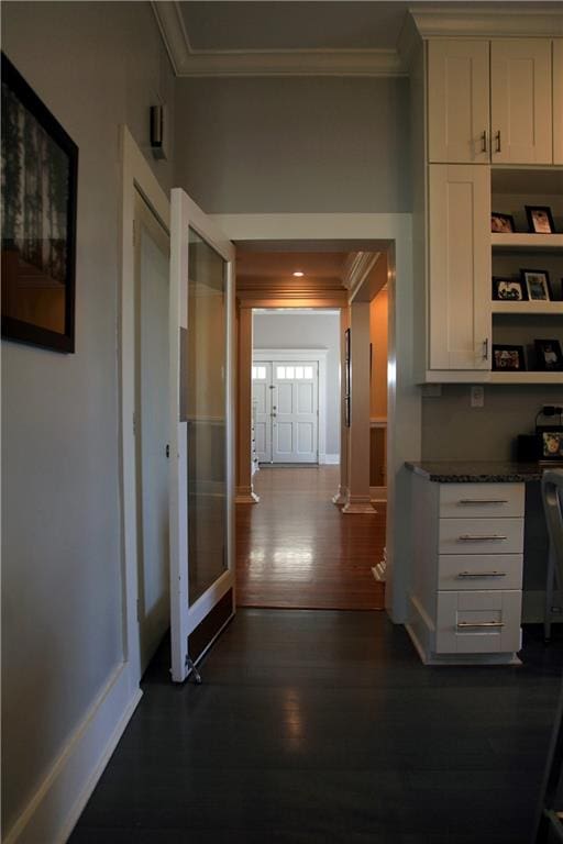 corridor with ornamental molding, dark wood-type flooring, and ornate columns