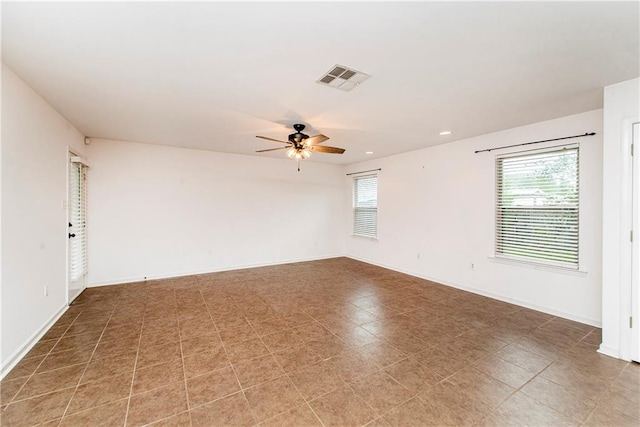 tiled spare room with ceiling fan