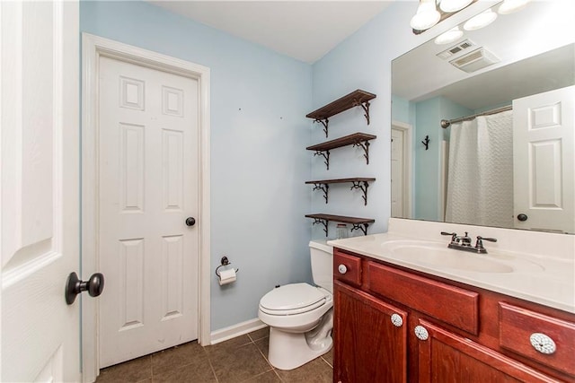 bathroom featuring toilet, walk in shower, vanity, and tile patterned floors