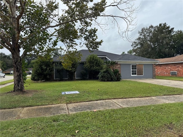 ranch-style house featuring concrete driveway, a front lawn, and roof with shingles