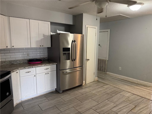 kitchen with wood tiled floor, stainless steel appliances, a ceiling fan, tasteful backsplash, and white cabinetry