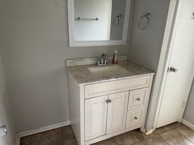 bathroom with baseboards, vanity, and tile patterned floors