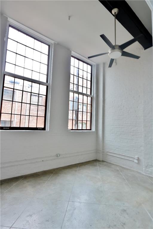 empty room featuring ceiling fan and plenty of natural light