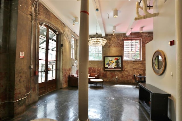 interior space featuring french doors, beamed ceiling, and an inviting chandelier