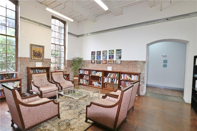 living room featuring brick wall and a high ceiling