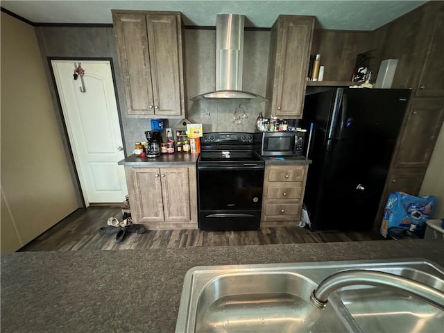 kitchen featuring dark hardwood / wood-style floors, wall chimney range hood, and black appliances