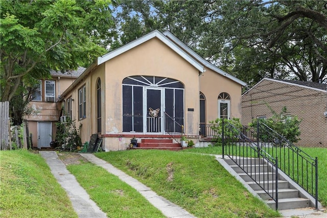 442527 Music St, New Orleans, LA 70122 - view of front facade featuring stucco siding and a front lawn