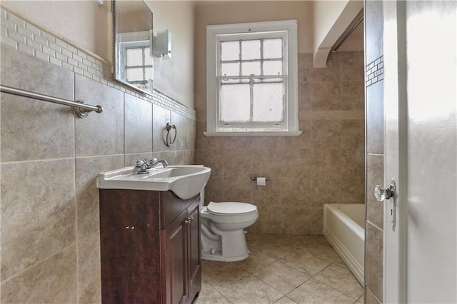 full bathroom with tile walls, tile patterned flooring, vanity, and toilet