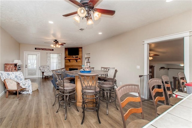 dining area featuring a textured ceiling, wood-type flooring, and ceiling fan