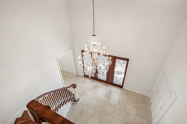 foyer with an inviting chandelier and a towering ceiling