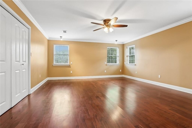 spare room with crown molding, dark wood-type flooring, and ceiling fan