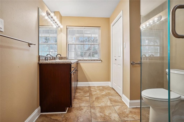 bathroom featuring tile patterned flooring, vanity, toilet, and a shower with shower door