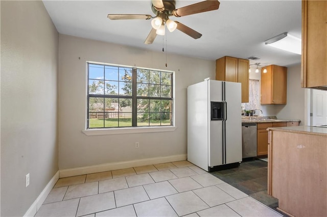 kitchen featuring light tile patterned floors, ceiling fan, dishwasher, and white refrigerator with ice dispenser