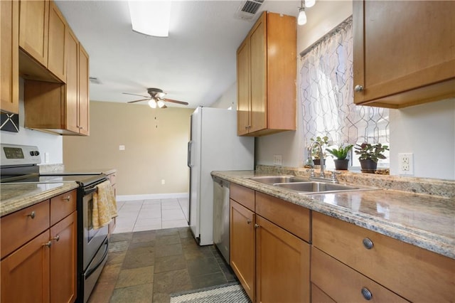 kitchen featuring ceiling fan, sink, light stone countertops, and appliances with stainless steel finishes