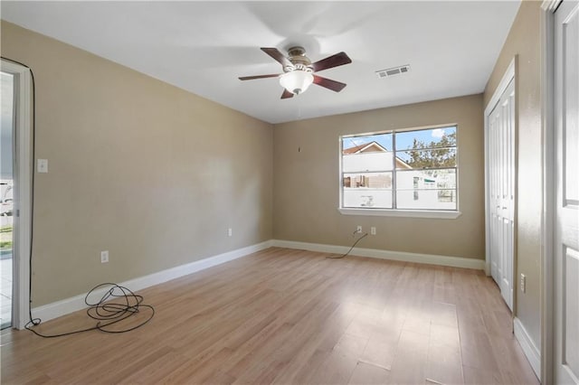 empty room with ceiling fan and light hardwood / wood-style floors