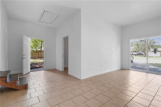 empty room with a wealth of natural light and light tile patterned flooring