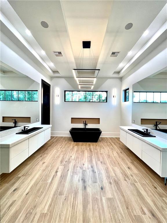 bathroom with a tub to relax in, vanity, and hardwood / wood-style flooring