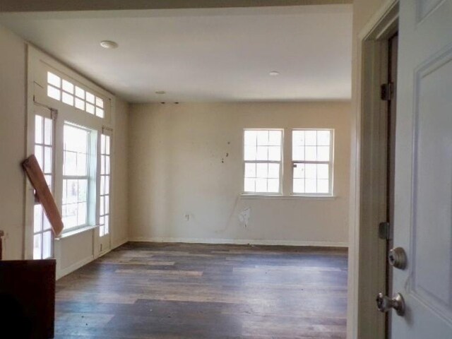 empty room featuring plenty of natural light and wood-type flooring