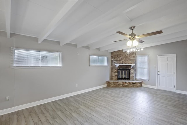 unfurnished living room featuring a wealth of natural light, light hardwood / wood-style floors, ceiling fan, and a fireplace