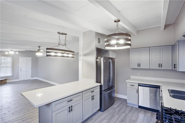 kitchen featuring pendant lighting, light hardwood / wood-style floors, ceiling fan with notable chandelier, beam ceiling, and appliances with stainless steel finishes