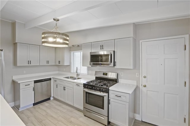 kitchen featuring pendant lighting, light hardwood / wood-style floors, sink, beam ceiling, and appliances with stainless steel finishes