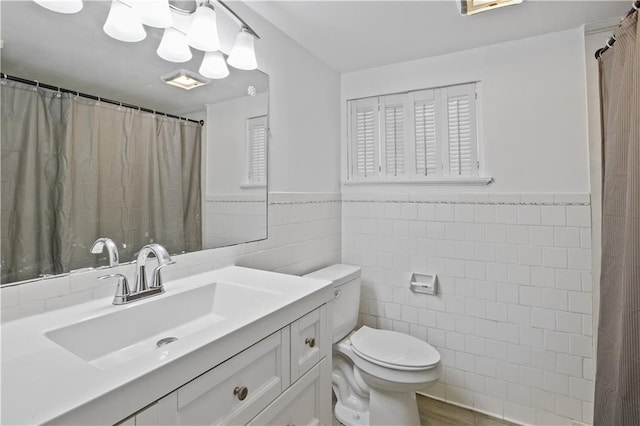 bathroom featuring tile walls, vanity, and toilet