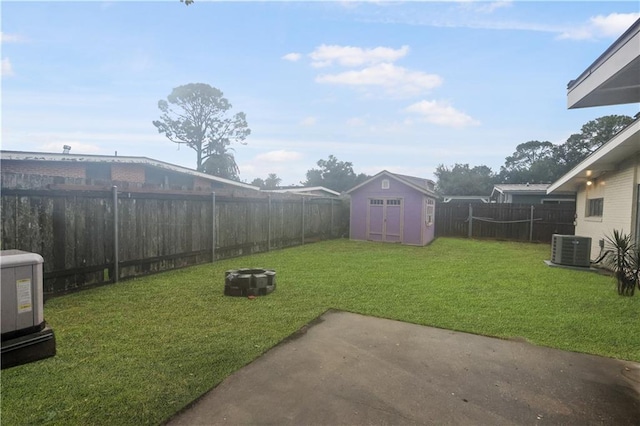 view of yard featuring cooling unit, a storage unit, and a patio area