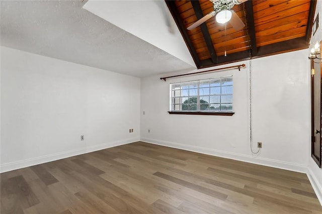 unfurnished room with a textured ceiling, vaulted ceiling with beams, ceiling fan, dark hardwood / wood-style floors, and wood ceiling