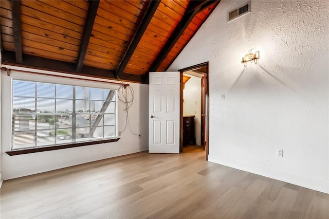 unfurnished room with wood ceiling, hardwood / wood-style flooring, and vaulted ceiling with beams