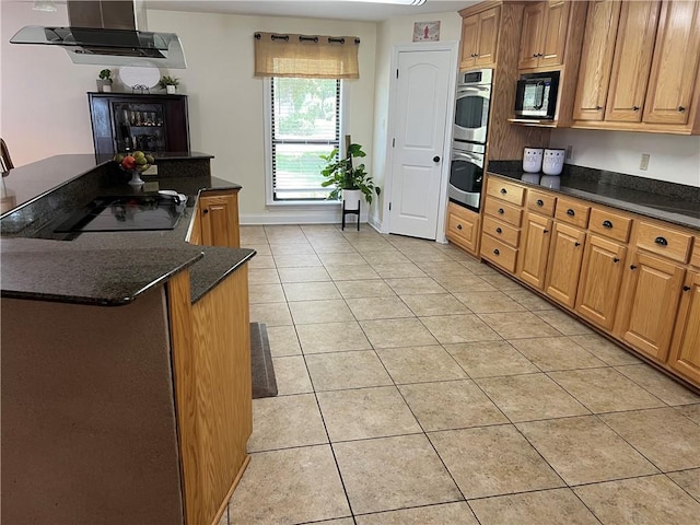 kitchen with wall chimney exhaust hood, black appliances, dark stone countertops, and light tile patterned flooring