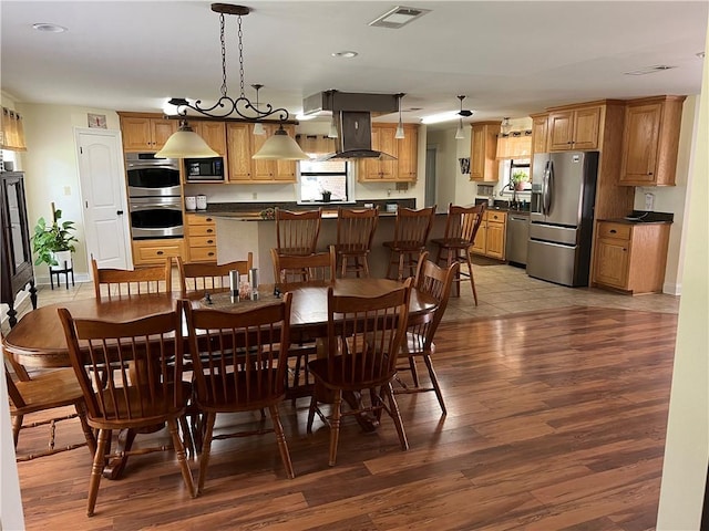 dining area with a healthy amount of sunlight, an inviting chandelier, and light hardwood / wood-style floors