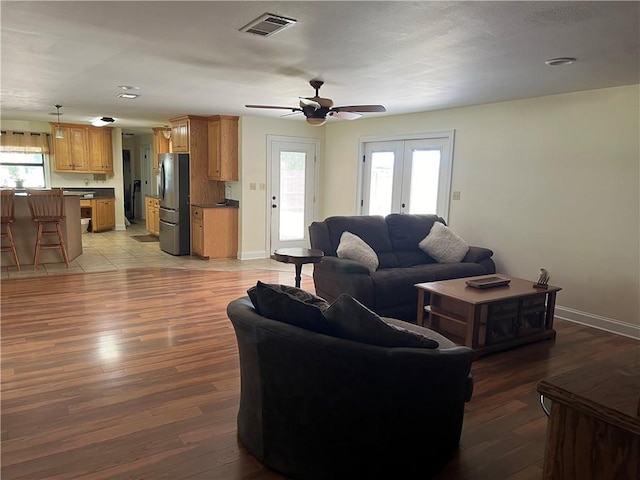 living room with french doors, ceiling fan, and light hardwood / wood-style floors