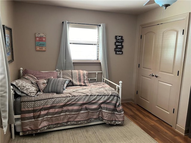 bedroom with a closet, ceiling fan, and dark hardwood / wood-style flooring