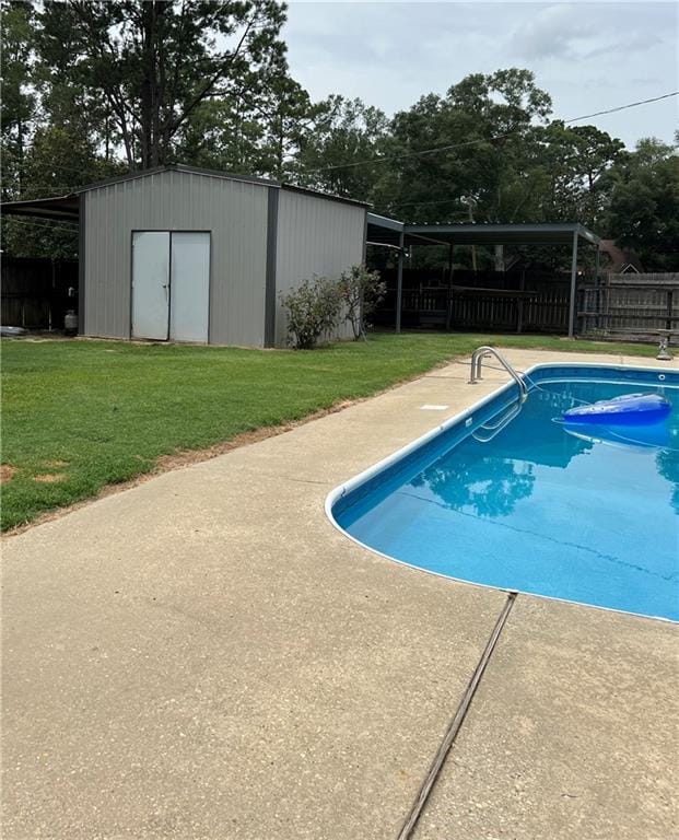 view of pool with a storage shed, a yard, and a patio